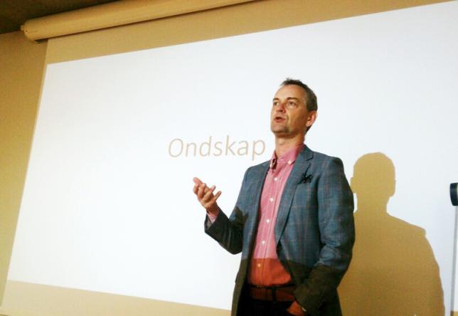 Mann står foran lerret i undervisningssituasjon