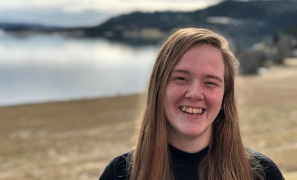 Student ute ved fjord og åker