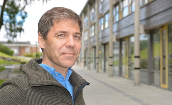 Mann ute foran universitetsbygg