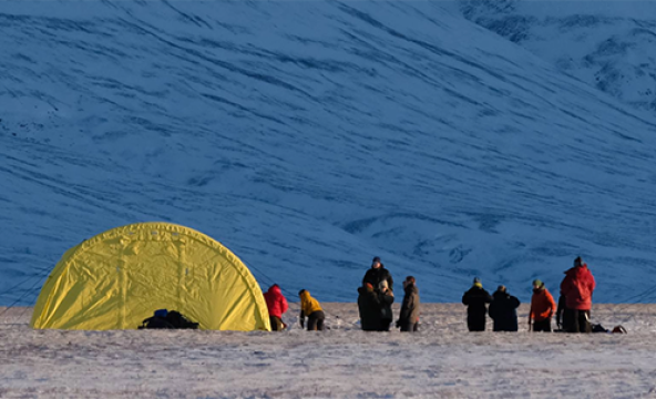 Telt ved foten av snødekt fjell