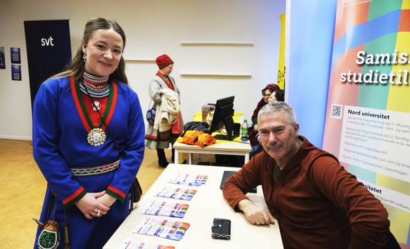 Kvinne med kofte besøker stand
