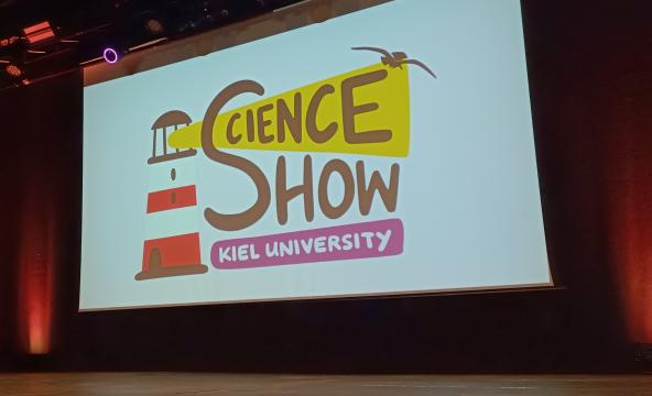 A big screen on a stage, saying "Science Show"