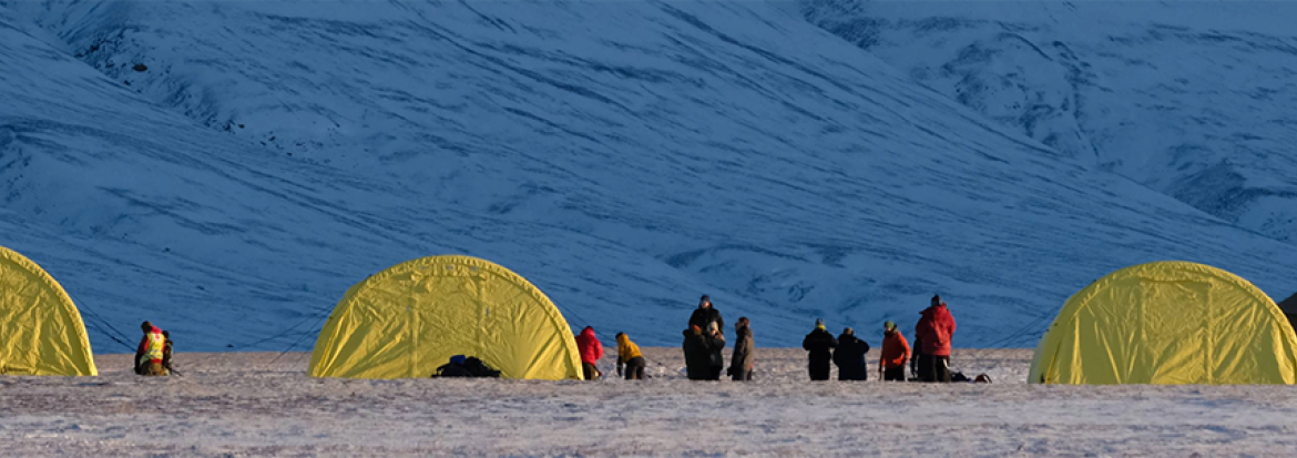 Telt ved foten av snødekt fjell