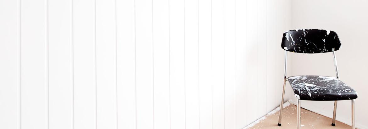 Illustrasjonsbilde av tom stol i et hjørne i et rom som skal males