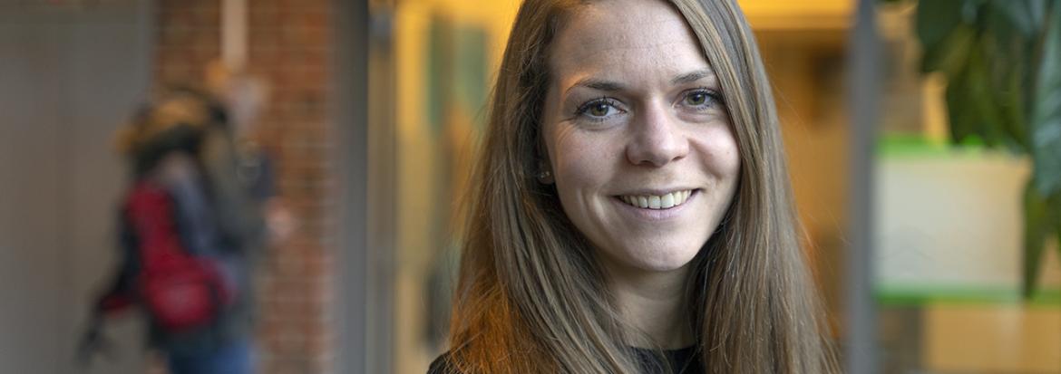 Portrett av ung kvinne inne i korridor. Foto