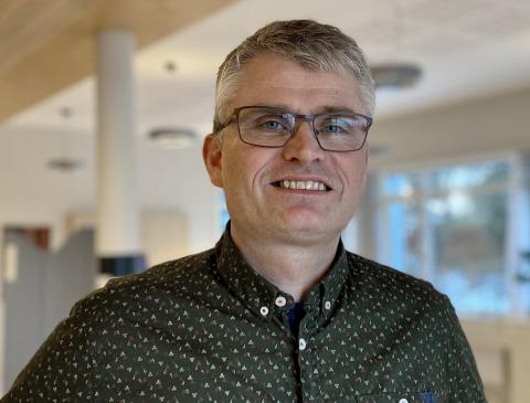 Mann i mørk skjorte. Foto.