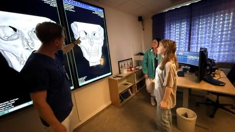 Elev og lærer foran stor skjerm på et sykehus. Foto