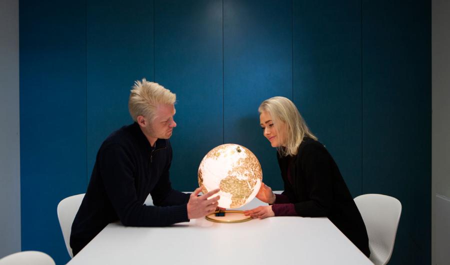 Studenter sitter ved et bord med en globus