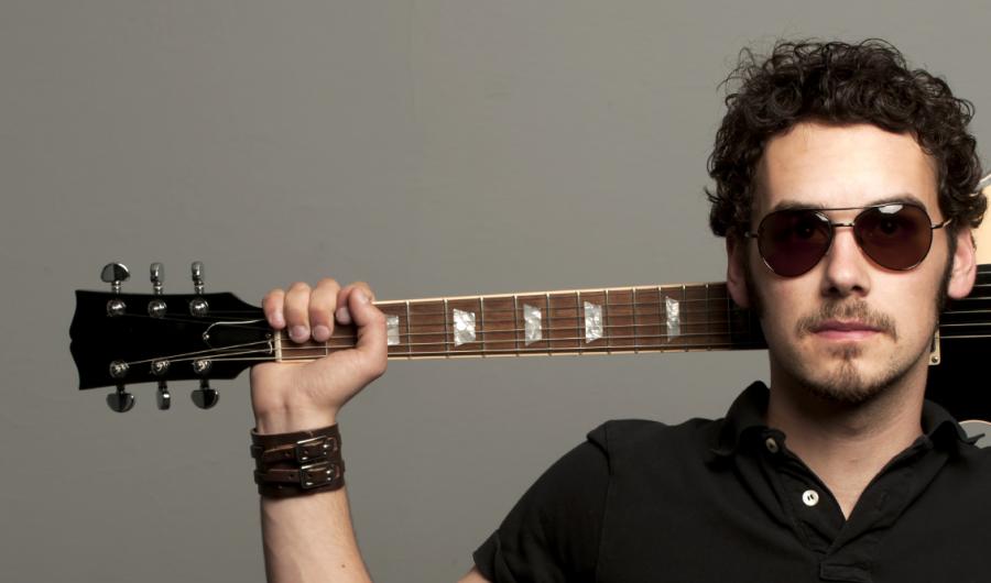 Mann med gitar bak nakken.