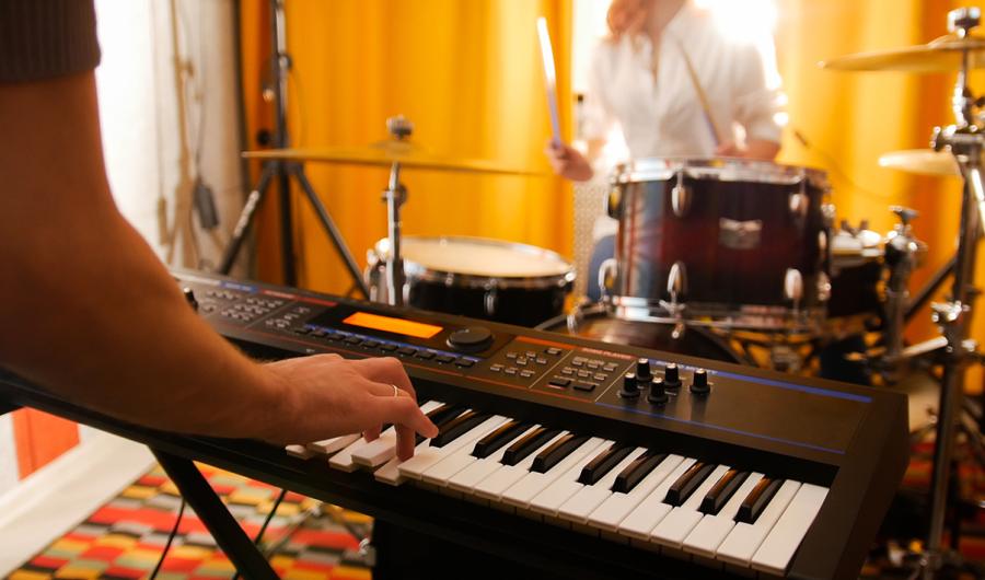 Musikere som spiller på elpiano og trommer.