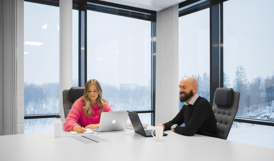 To personer i møte ved pc-ene sine