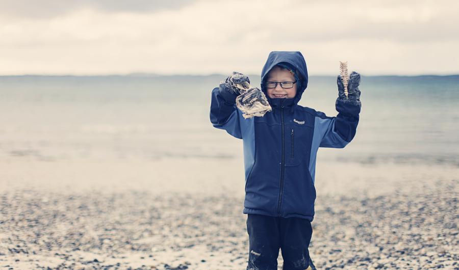 Gutt som leker i fjæra.