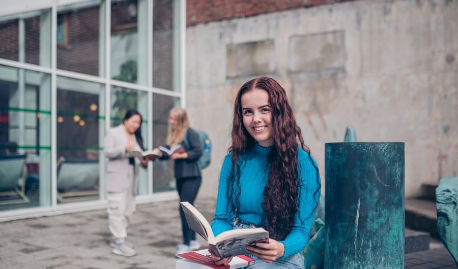 Student med bok i kinesisk hage