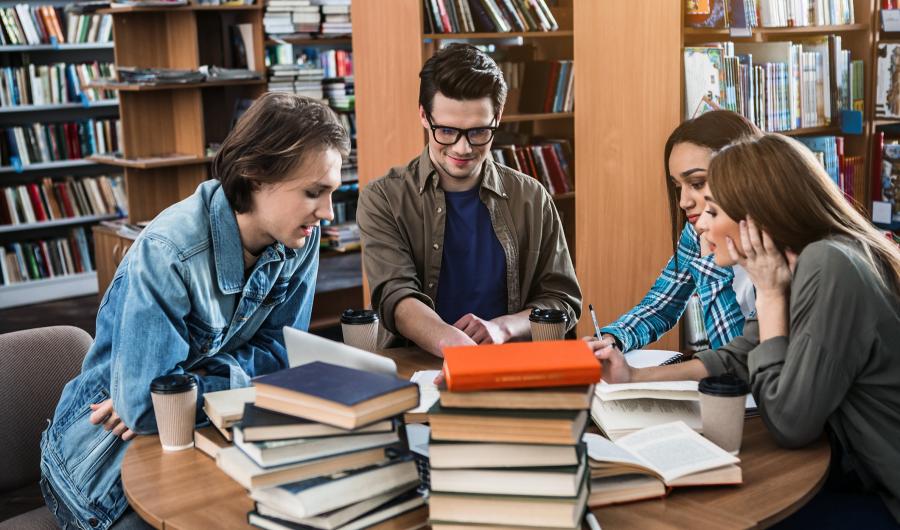 Fire studenter som arbeider i et bibliotek