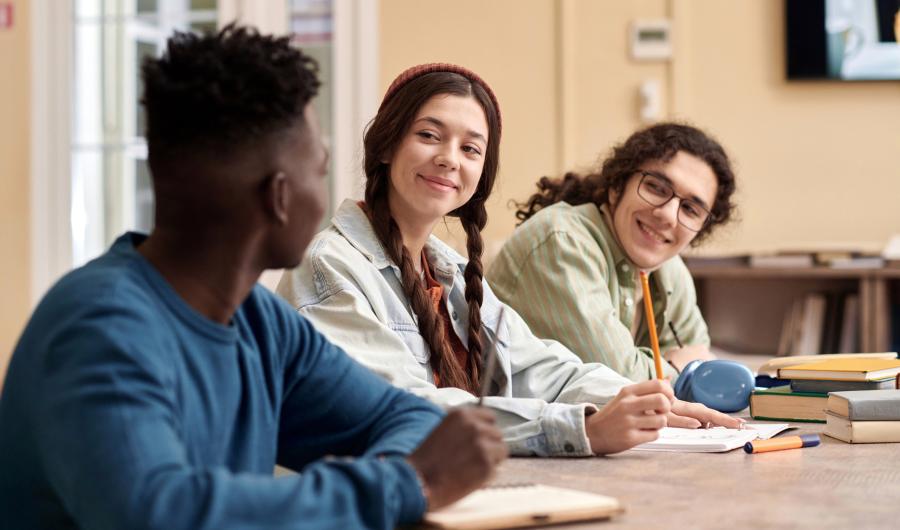 Tre studenter som arbeider ved et bord.