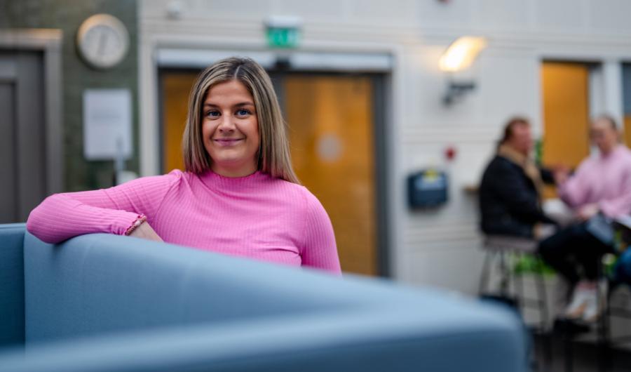 HR-ledelse nettbasert deltidsstudie: ung kvinne som ser inn i kameraet