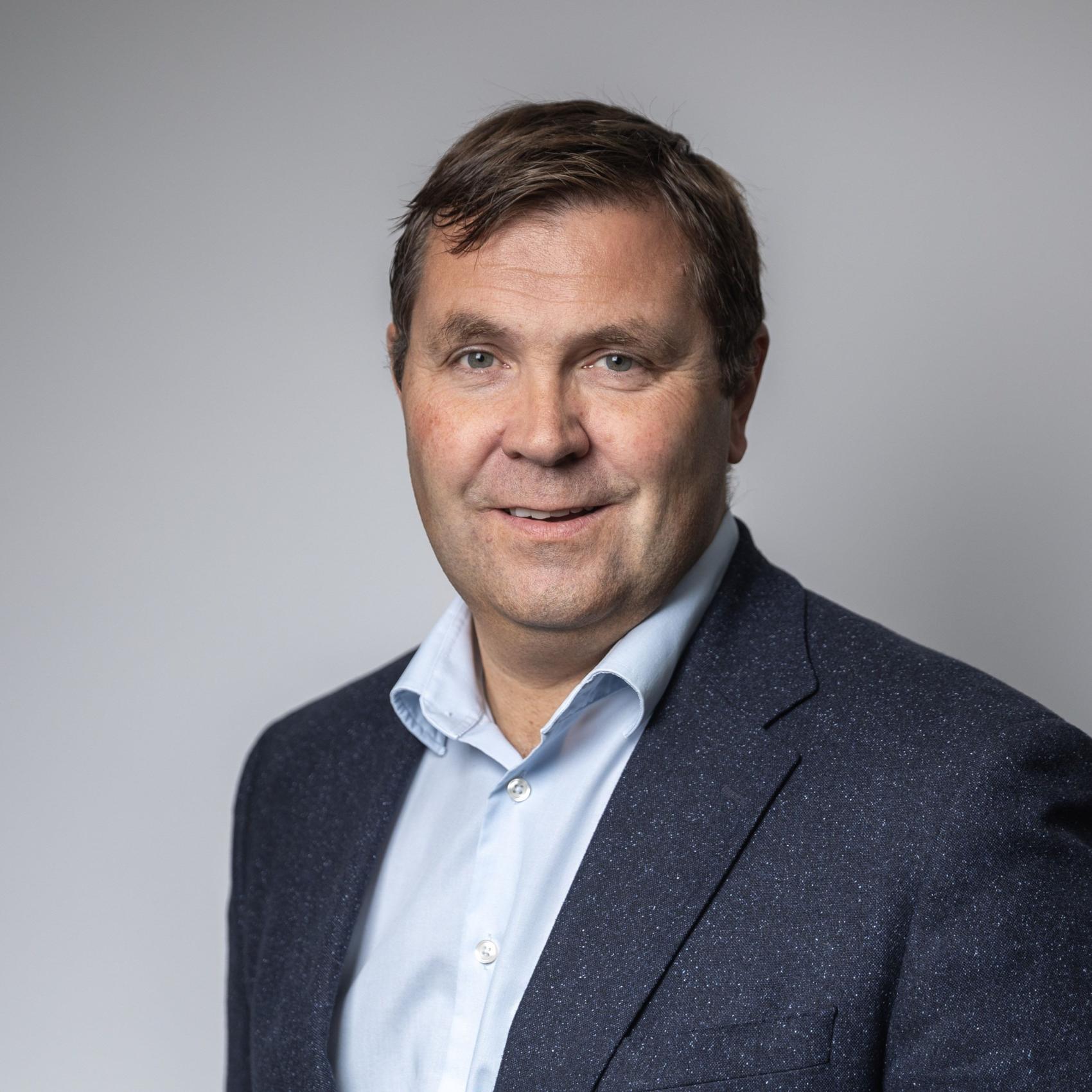 Mann med brunt hår og blå jakke