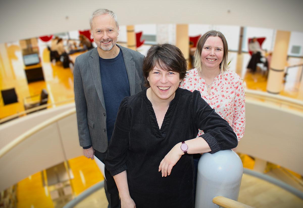 Tre personer i trapp på bibliotek