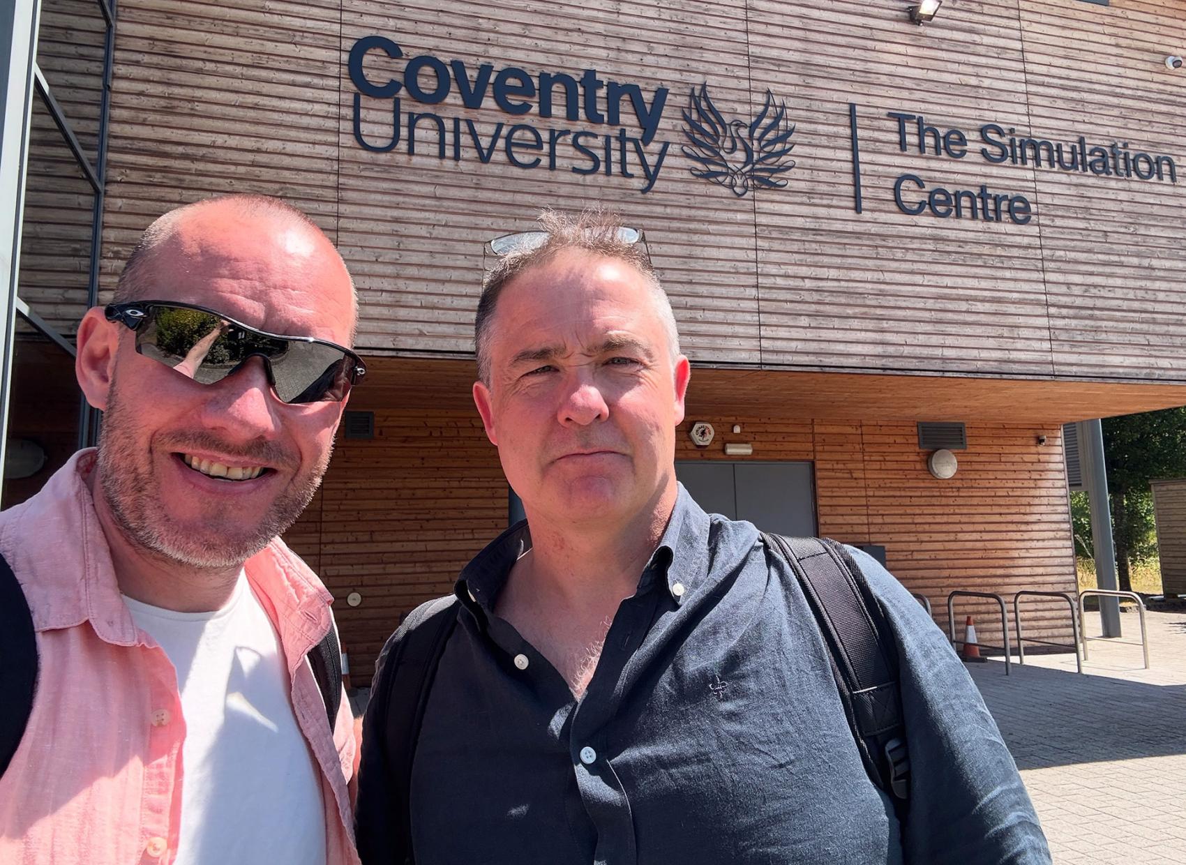 To menn utenfor universitetsbygg i England. Foto