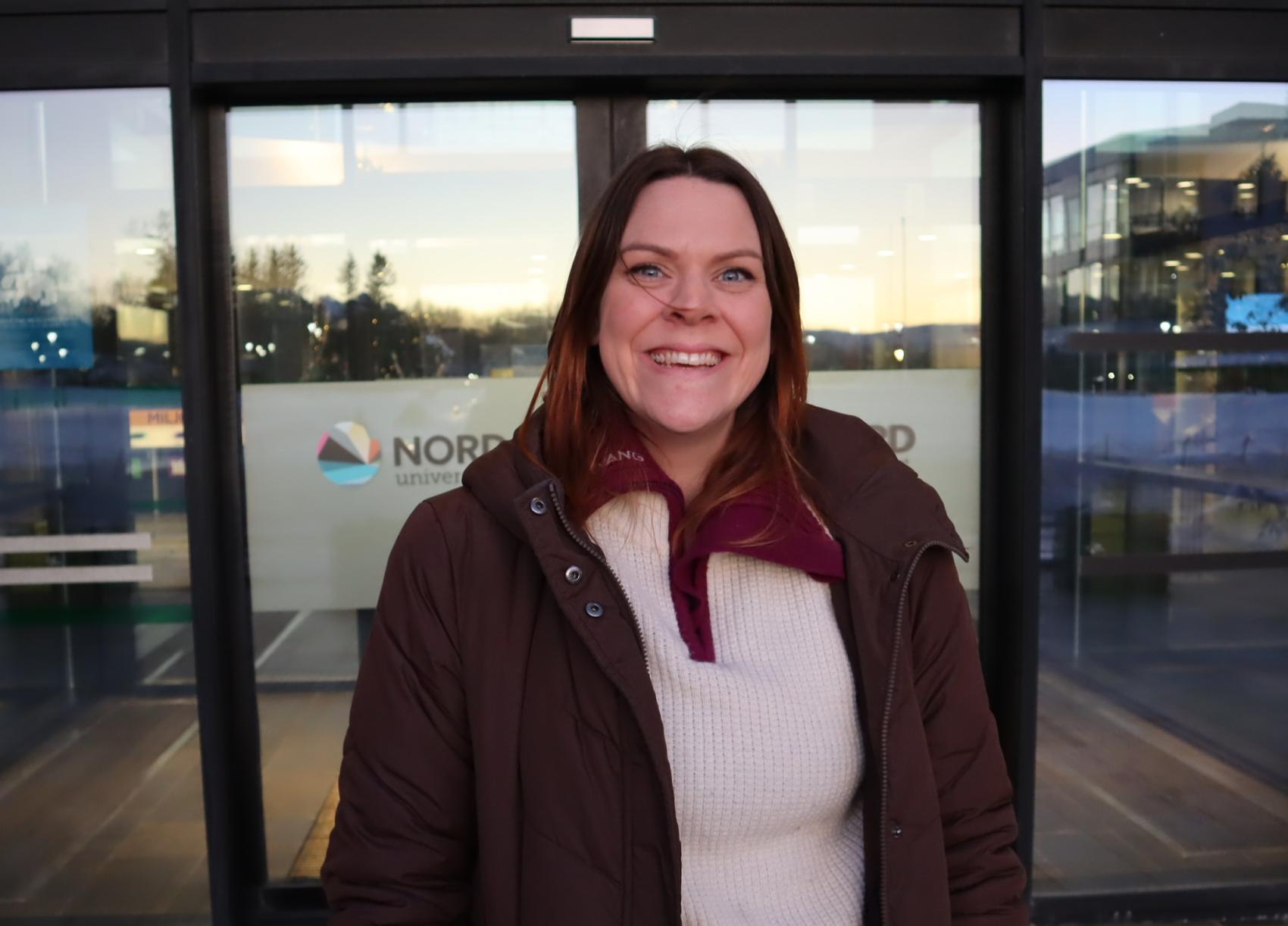 Smilende kvinne utenfor campus Mørkved