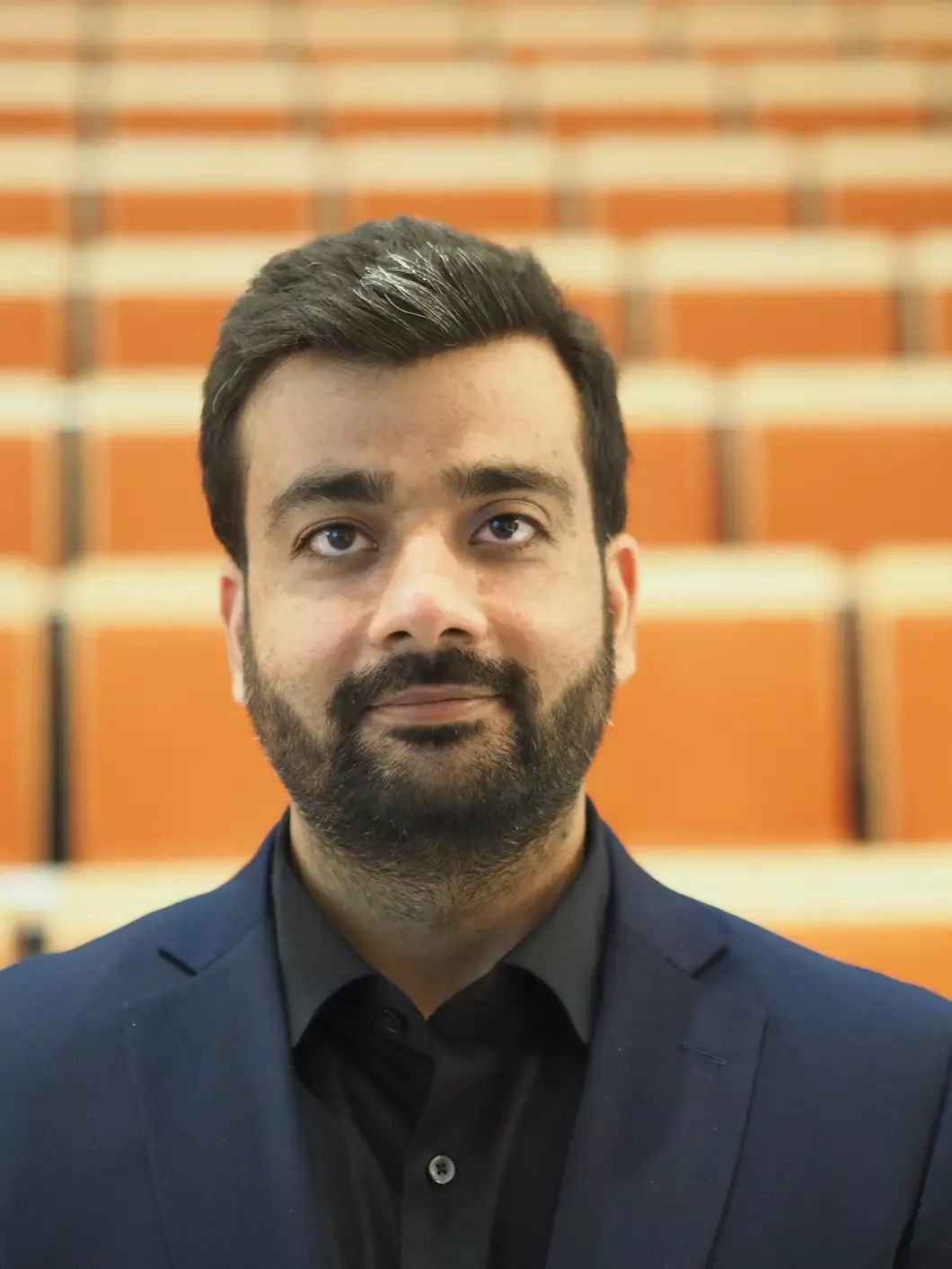 Portrett av en mann med skjegg i dress. Foto