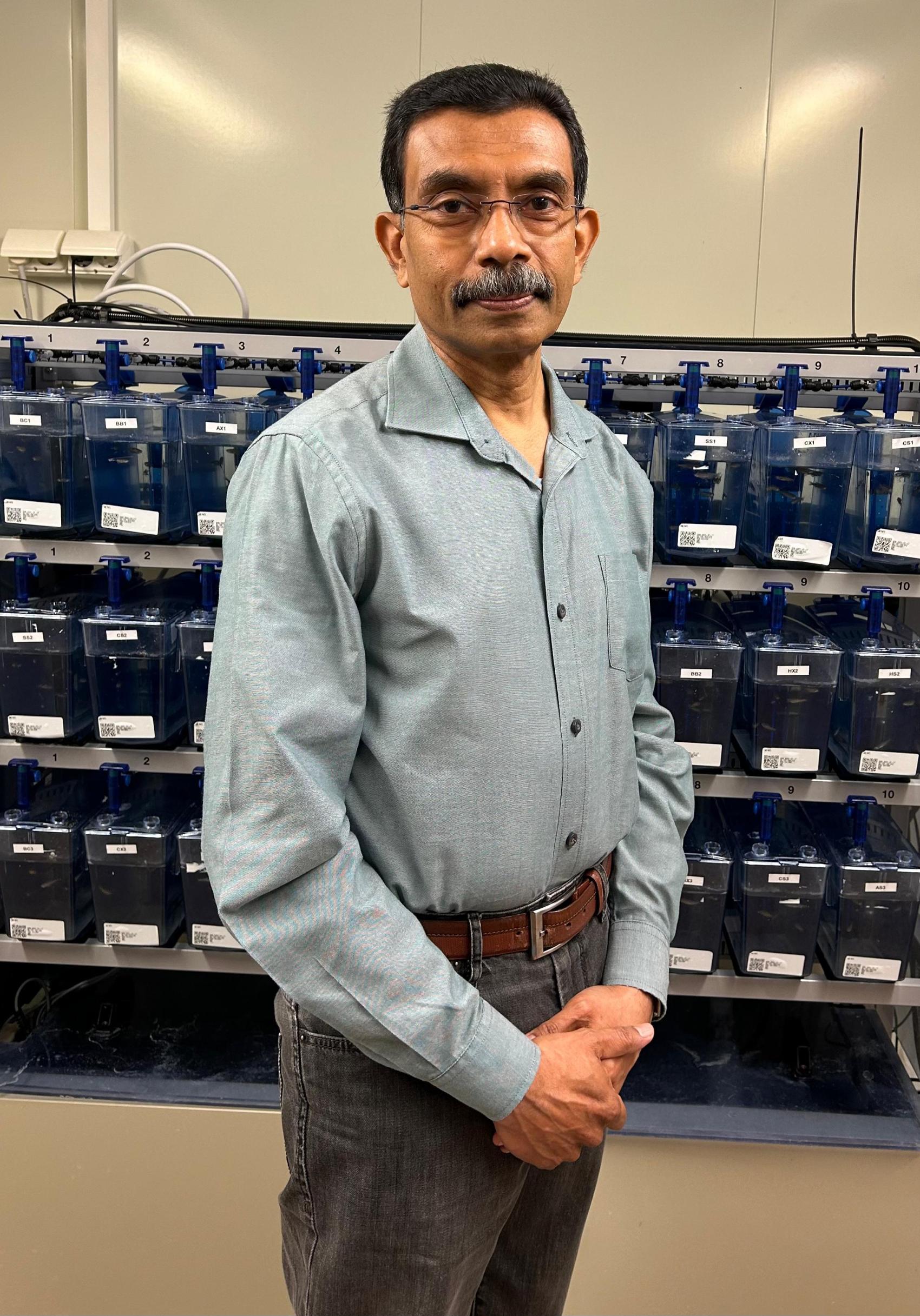 Mann i pen skjorte inne på en forskningsstasjon. Foto