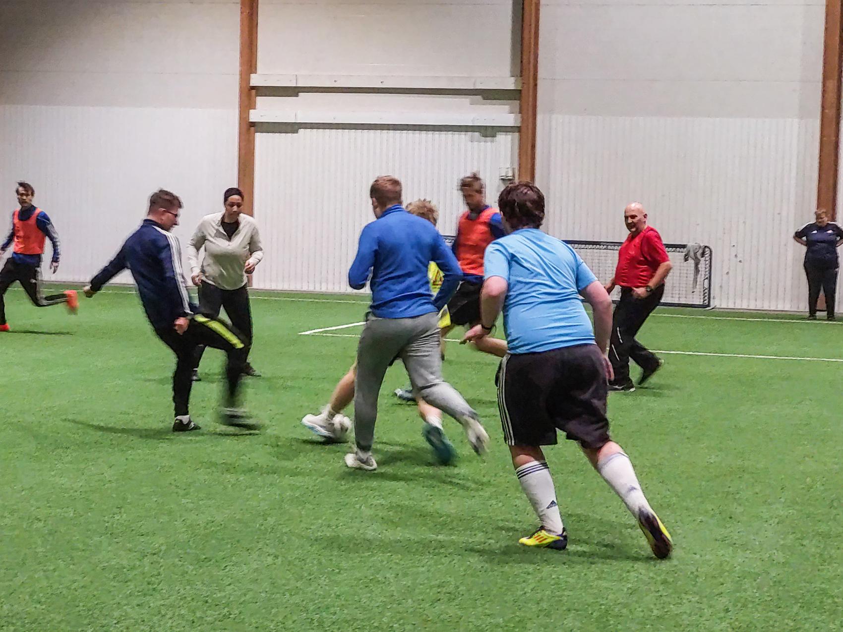 Fotballspillere som sparker fotball på trening inne i en hall. Foto