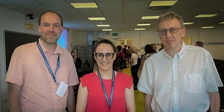 To menn og en dame inne i konferansesal