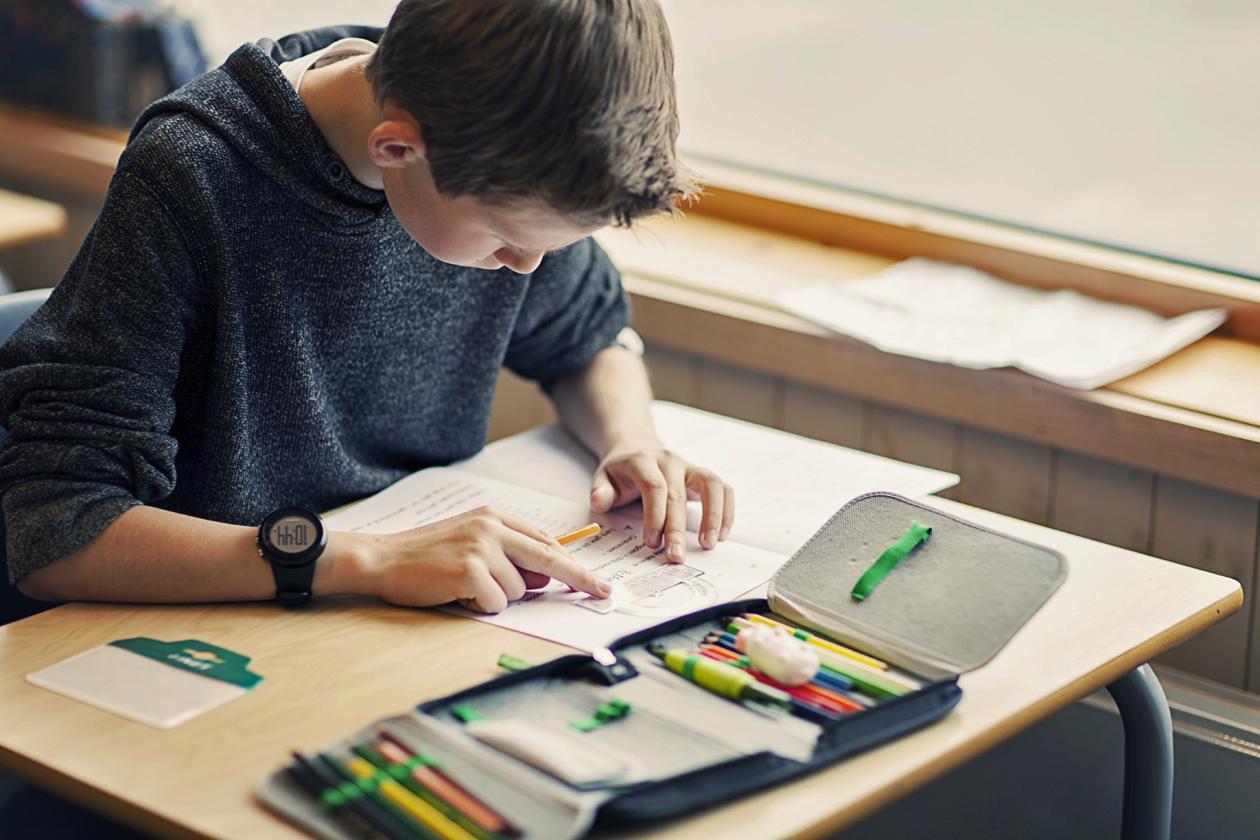 Elev arbeider ved pulten.