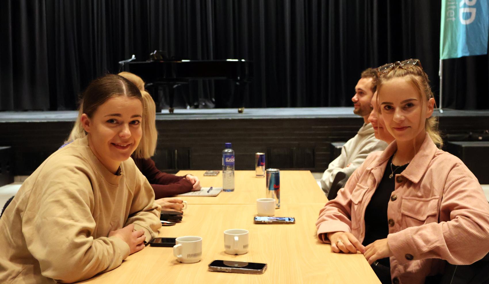 Unge kvinner rundt et bord. Foto